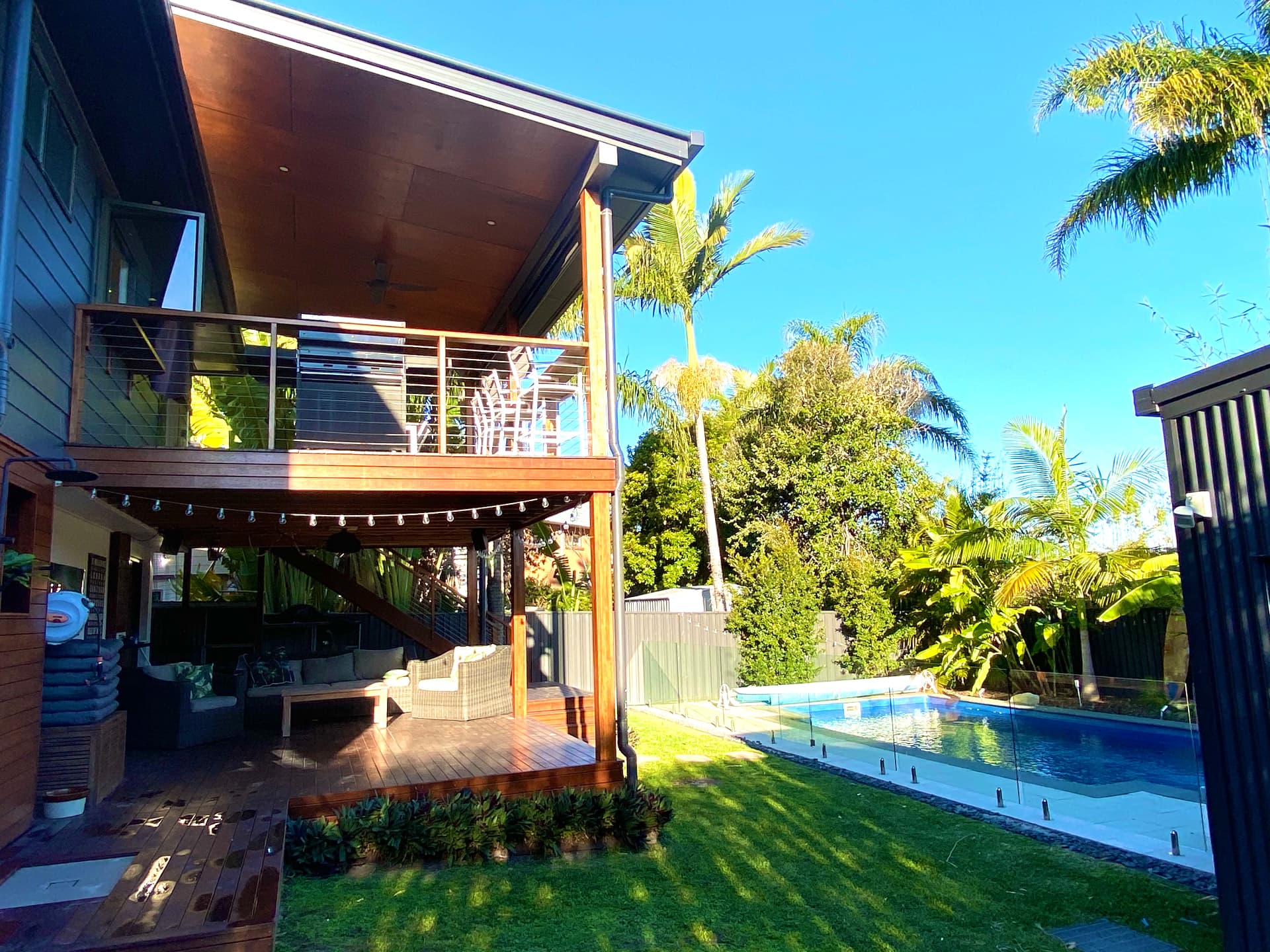 Upper and lower outdoor living areas connected to the pool and garden